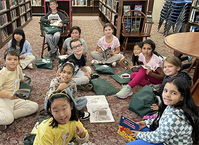 Students sitting on the floor at the library reading books