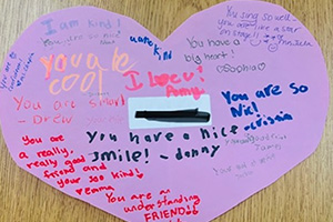 Messages written on a pink paper heart