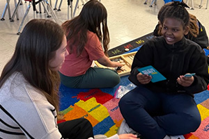 An adult playing games with students