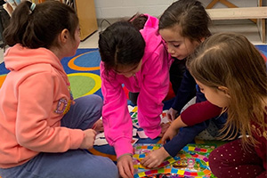 Four students playing a board game