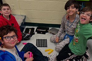 Four students playing a game with cubes