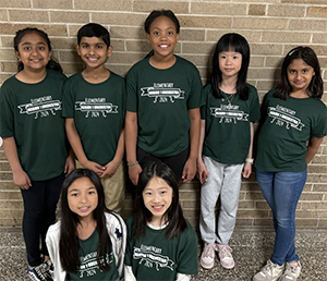 Seven orchestra students in green shirts and jeans