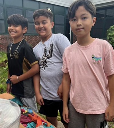 Students standing next to a box of garden gloves